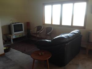 a living room with a couch and a tv at Casa Cleo - Somente carro 4x4 ou fazemos translado sem custo in São Francisco Xavier