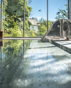a swimming pool with a glass floor in a house at Hotel Bemelmans-Post in Collalbo