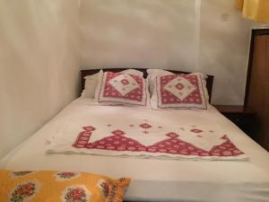 a bed with red and white pillows on it at Family Room for 6 peoples Sunny Riad Inside Medina Fes El Bali in Fez