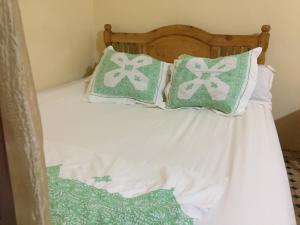 a bed with green and white pillows on it at Family Room for 6 peoples Sunny Riad Inside Medina Fes El Bali in Fez