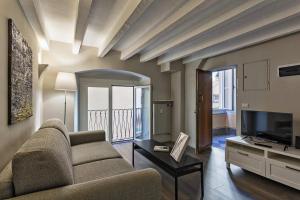 salon z kanapą i telewizorem w obiekcie Boutique Apartment in Via Roma by Wonderful Italy w Genui