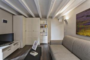 salon z kanapą i telewizorem w obiekcie Boutique Apartment in Via Roma by Wonderful Italy w Genui