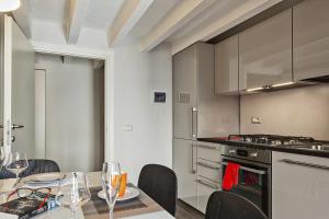 a kitchen with a table and chairs and a stove at Boutique Apartment in Via Roma by Wonderful Italy in Genoa