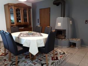 a dining room with a table and chairs and a stove at Ferienhaus Sonnenhang in Scheiden