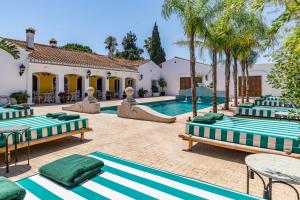 a courtyard with a pool with chaise lounges and a slide at Maison San Alfredo B&B in El Puig