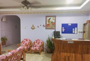 a room with chairs and a desk in a room at Keenomulok Holiday Home in Ranau