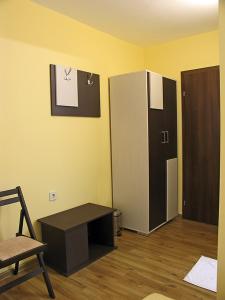 a room with a refrigerator and a table and a chair at Хотел Хисаря in Haskovo