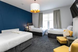 a hotel room with two beds and a window at Stay Coastal in Whitley Bay