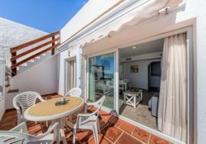 eine Terrasse mit einem Tisch und Stühlen auf dem Balkon in der Unterkunft Villas Flamenco Beach Conil in Conil de la Frontera