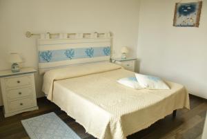 テルテニーアにあるCasa vacanza Lentisco D Sardegna Ogliastraのベッドルーム1室(ベッド1台、ナイトスタンド2台付)