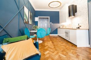 een blauwe woonkamer met blauwe stoelen en een keuken bij Charles Bridge Suite by Riverside in Praag