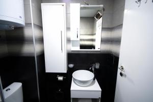 a small bathroom with a white toilet and a mirror at Apartmani Stančić in Banja Koviljača