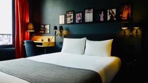 a bedroom with a bed and a desk in a room at Hôtel Noir in Paris