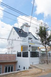 a white house with a black fence in front of it at S Villa Hotel in Da Thanh