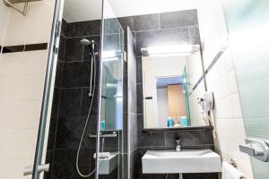 a bathroom with a sink and a shower at Bastion Hotel Breda in Breda +19 photos