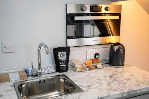 a kitchen counter with a sink and a microwave at Stay Coastal in Whitley Bay