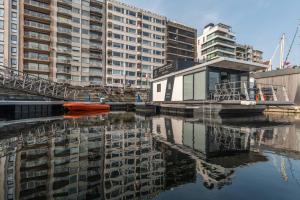un bote rojo en el agua junto a algunos edificios en Houseboat by C-Hotels Burlington, en Ostende