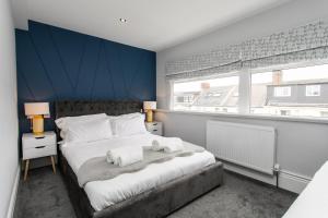 a bedroom with a large bed with towels on it at Stay Coastal in Whitley Bay