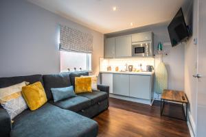 a living room with a couch and a kitchen at Stay Coastal in Whitley Bay
