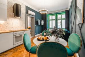 cocina con mesa y sillas verdes en Charles Bridge Suite by Riverside, en Praga