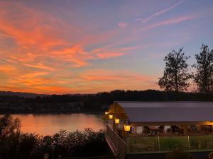 a sunset over a lake with a building in front at Hotel-Restaurant Faustschlössl in Feldkirchen an der Donau