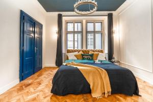 a bedroom with a large bed and a blue door at Charles Bridge Suite by Riverside in Prague