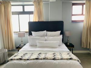 um quarto com uma cama grande com lençóis brancos e almofadas em Kings View em Margate