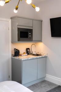 a kitchen with a sink and a microwave at Stay Coastal in Whitley Bay