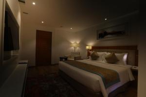 a hotel room with a large bed and a television at Best Western Plus Tejvivaan in Visakhapatnam