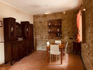 comedor con mesa, sillas y pared de piedra en villa aurora, en Francavilla di Sicilia