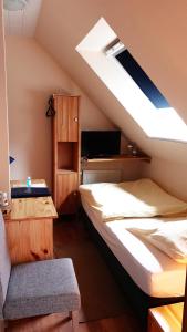 Habitación en el ático con 2 camas y silla en Haus Scheuten Hotel en Duisburg