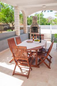 een tafel en stoelen op een patio met een open haard bij VILLA MIA TROGIR in Trogir