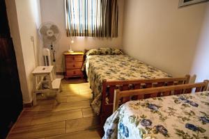 um pequeno quarto com 2 camas e uma ventoinha em Casa Capitan con vista mar em Arona