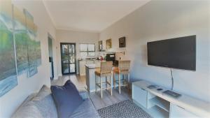 a living room with a couch and a flat screen tv at Stoneridge farm in Plettenberg Bay
