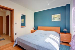 a bedroom with a blue wall and a bed at Apartments Universe in Pula