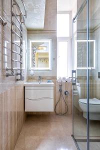 uma casa de banho com um lavatório, um WC e um espelho. em 2 bedroom apartment Tykha street city center with parking place em Lviv