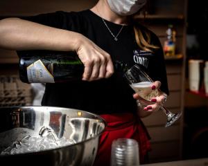 特拉维夫电影院酒店阿特拉斯酒店集团的把一瓶酒倒进玻璃杯中的女人