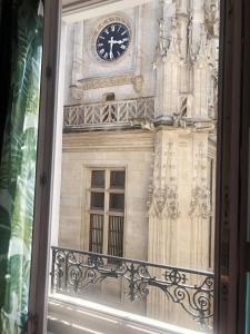 um relógio na lateral de um edifício com uma janela em ROUEN centre ville Palais de Justice em Rouen