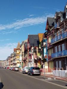 a row of buildings on a street with cars parked at Studio Mer Centre équestre in Mers-les-Bains