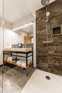 La salle de bains est pourvue d'un lavabo et d'une douche. dans l'établissement Cabin8 Alpine Flair Apartments, à Pertisau