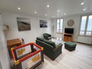 a living room with a couch and chairs and a tv at Le Nid de la Baie de Somme in Friville-Escarbotin