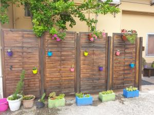 ein Holzzaun mit Topfpflanzen darauf in der Unterkunft Oasi B&B in Benevento