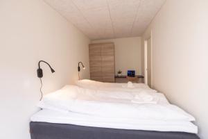 ein Schlafzimmer mit einem großen weißen Bett in einem Zimmer in der Unterkunft Panorama boathouse in Klaksvík