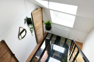 un escalier ouvert avec une fenêtre et des plantes en pot dans l'établissement MAISON VIEUX LILLE 3 chambres parking privé 24H24H Accès, à Lille