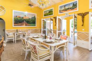 une salle à manger avec des murs jaunes, une table et des chaises dans l'établissement Maison San Alfredo B&B, à El Puig