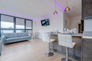a kitchen and living room with a bar and a couch at Central Penthouse with Hot Tub & Views 23 in Cheltenham