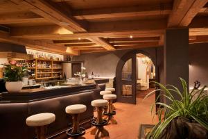 a bar in a restaurant with stools at Dolomites Wellness Hotel Savoy in La Villa