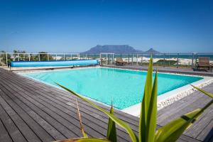 una piscina en una terraza con el océano en el fondo en Spacious Luxury 3 Bedroom Apartment B401 Sea Spray, en Ciudad del Cabo