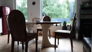 a table and chairs in a kitchen with a window at Ecki's Ferienhaus "KOMM an de BÄK" mit 5 Sternen bewertet bei Google und Traumferienwohnungen in Alt Schönau