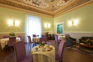 uma sala de jantar com mesas e cadeiras e um tecto em Hotel Firenze Capitale em Florença